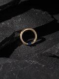 BVLA Gold ring with a blue gemstone on a dark stone surface