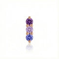 Gold earring with purple and blue gemstones on a white background