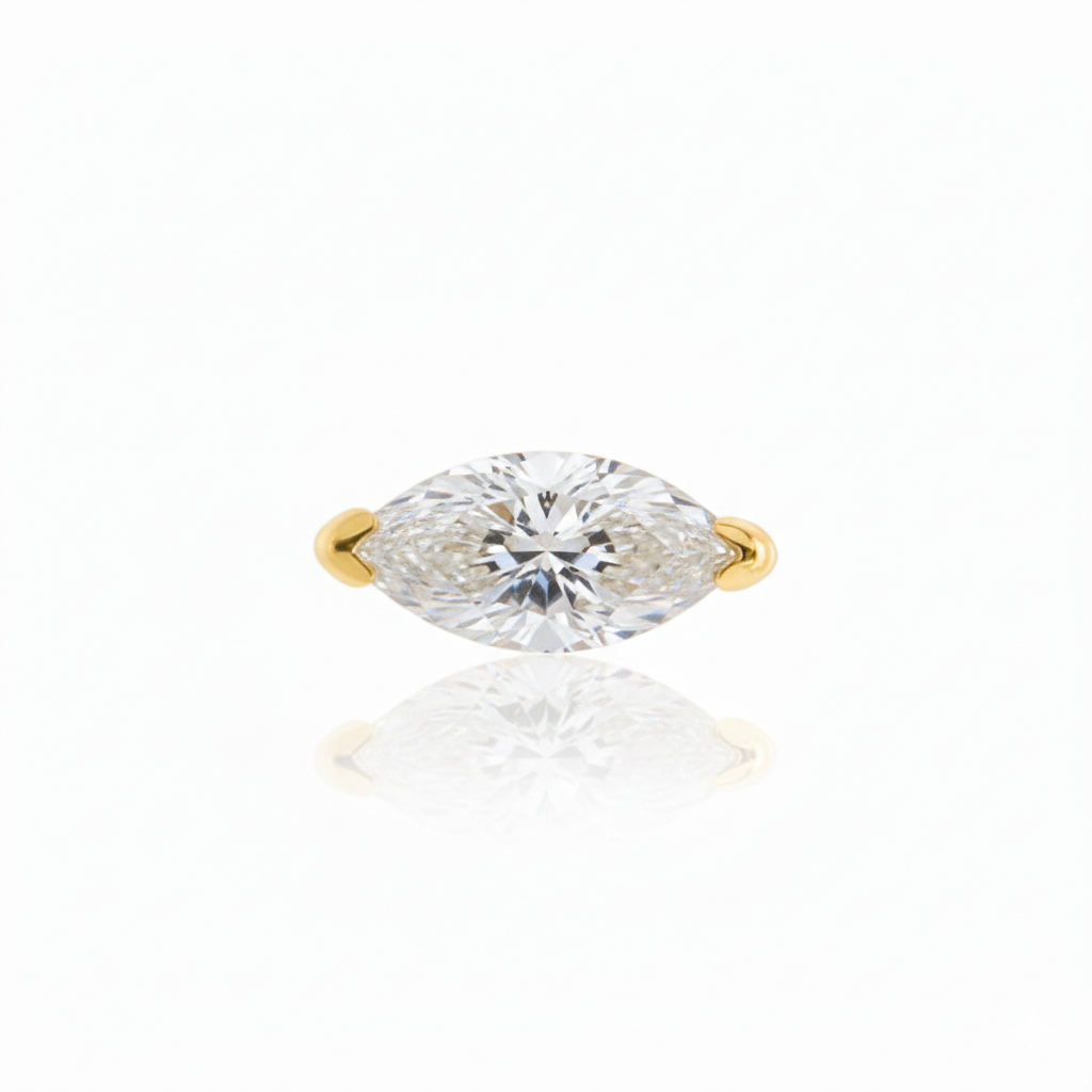 Gold ring with a marquise-shaped diamond on a white background