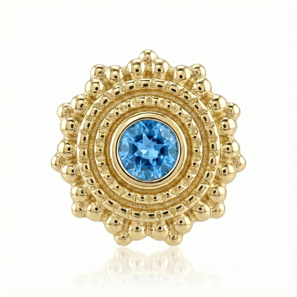 Gold charm with a blue gemstone on a white background